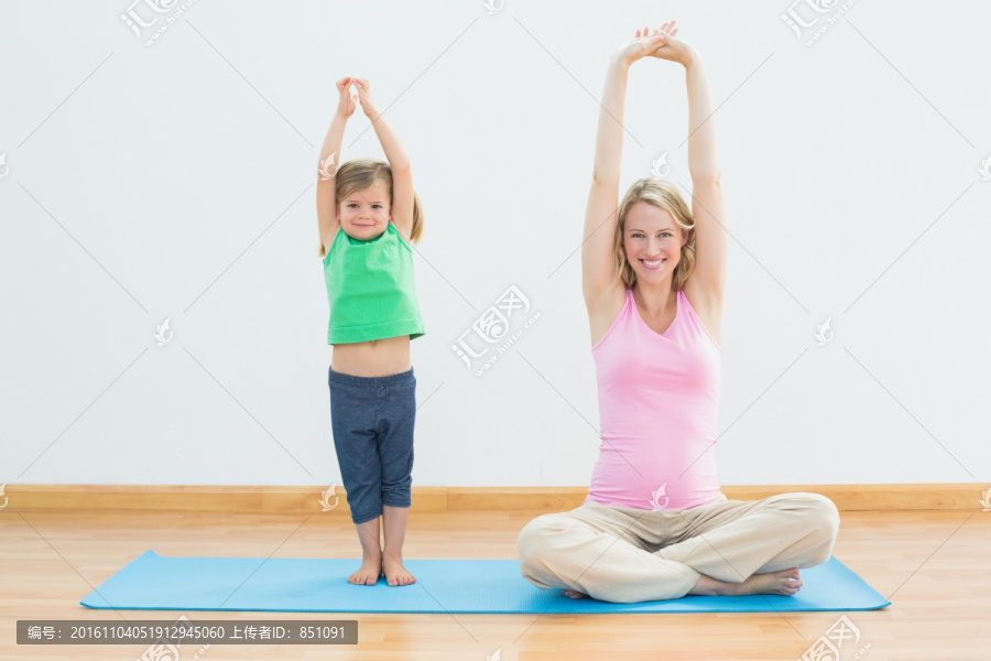 孕妇妈妈和女儿一起健身房做瑜伽