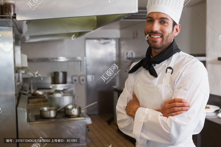 微笑的年轻厨师站厨房里
