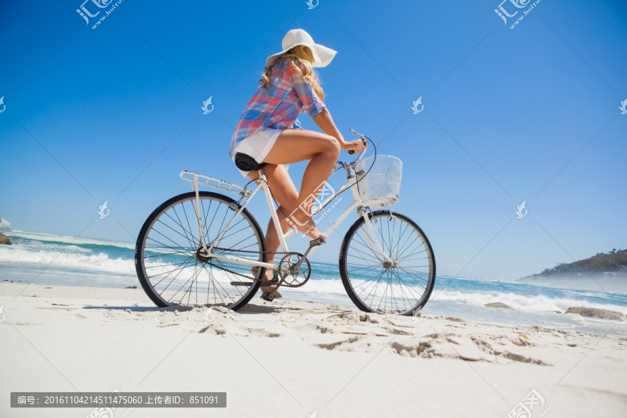 在海边上骑着自行车的女人