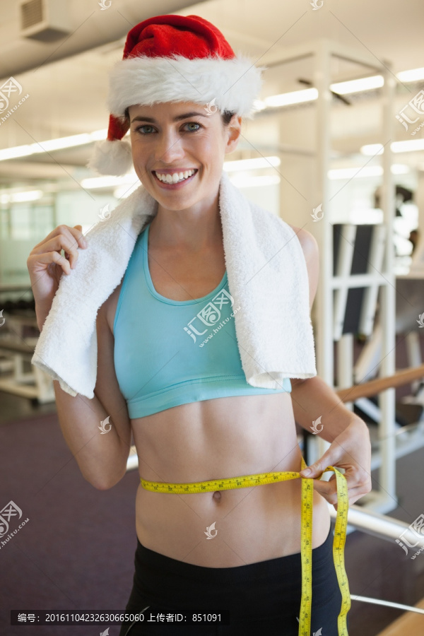 在健身房里测量腰围的女人