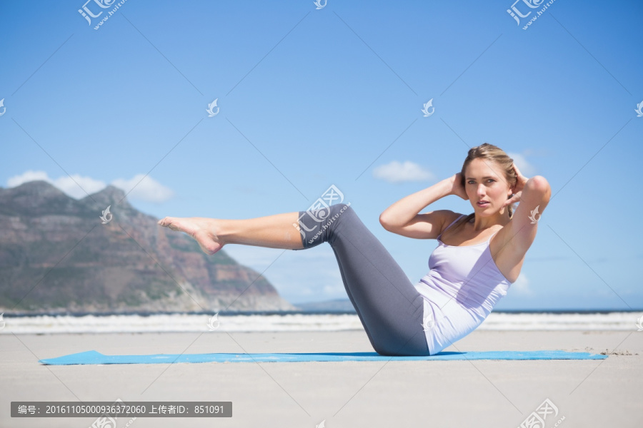 在沙滩上做瑜伽的专注女人