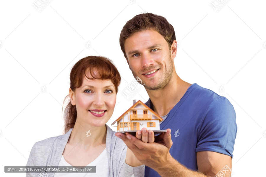 拿着一个房子模型的夫妇