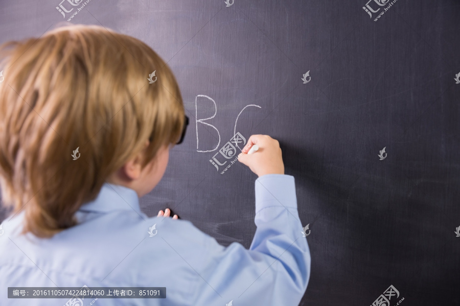 在黑板上书写的男学生