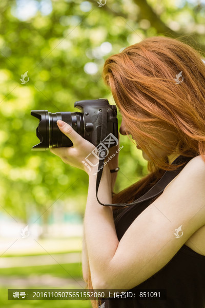 在公园里用相机拍照的女摄影师