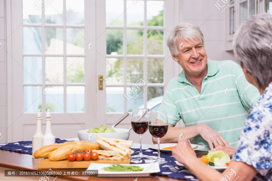 在厨房里吃饭的一对老夫妇