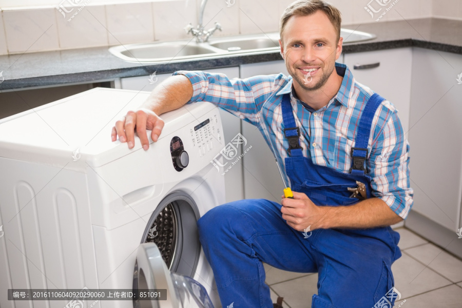 在修理洗衣机的男工人