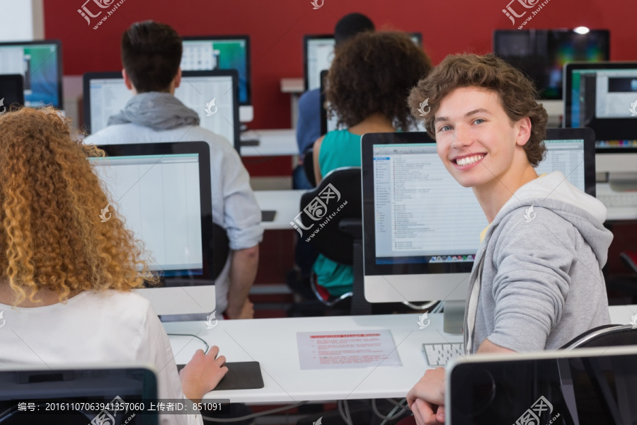 微笑的男大学生在上计算机课
