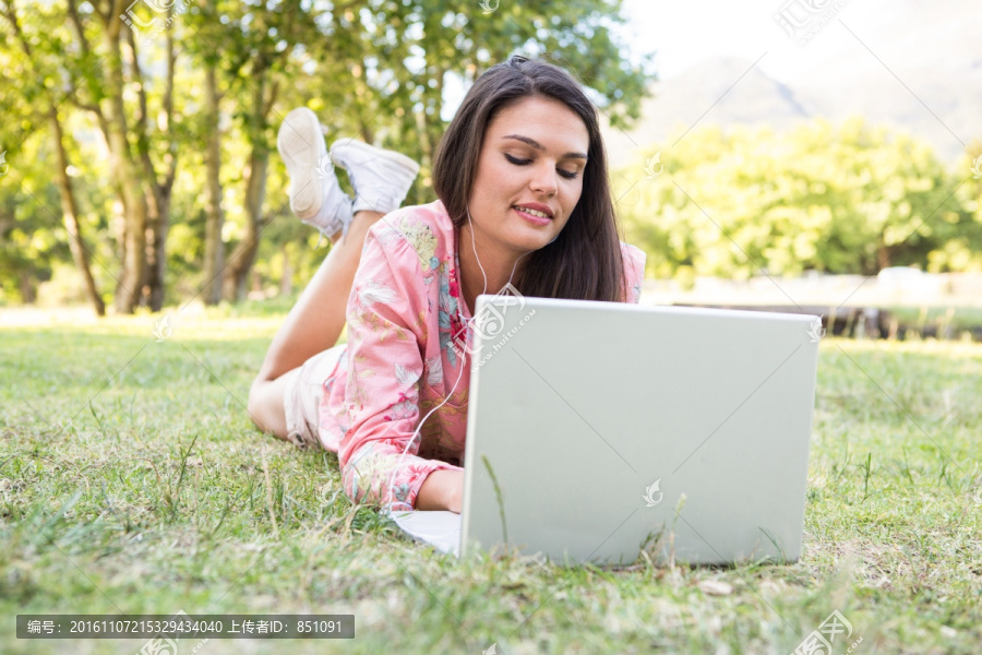 在公园里使用笔记本电脑的女人