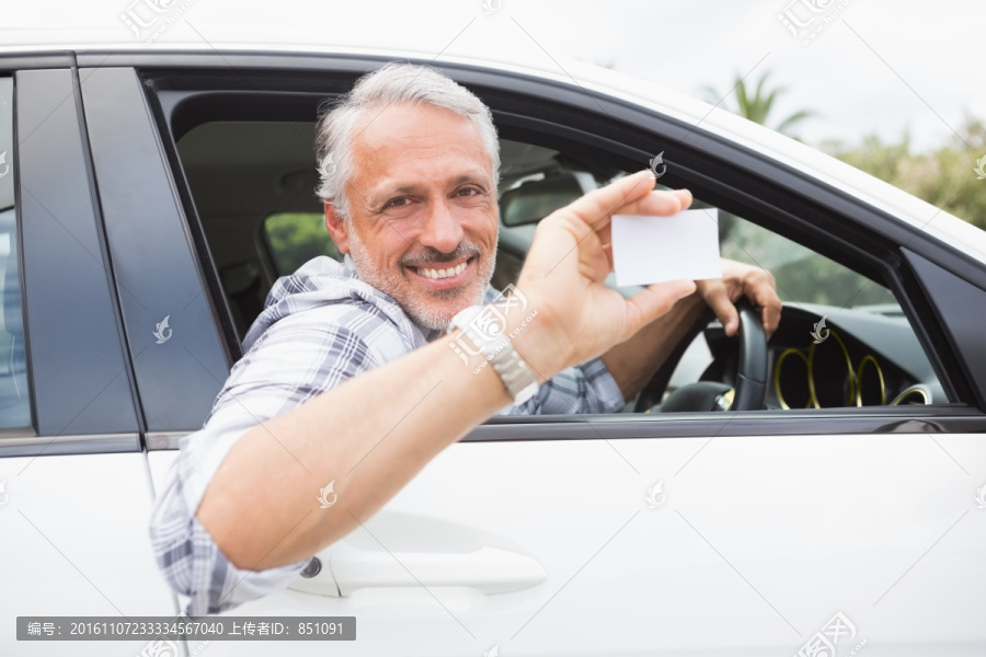 微笑着坐在车里拿着名片的男人