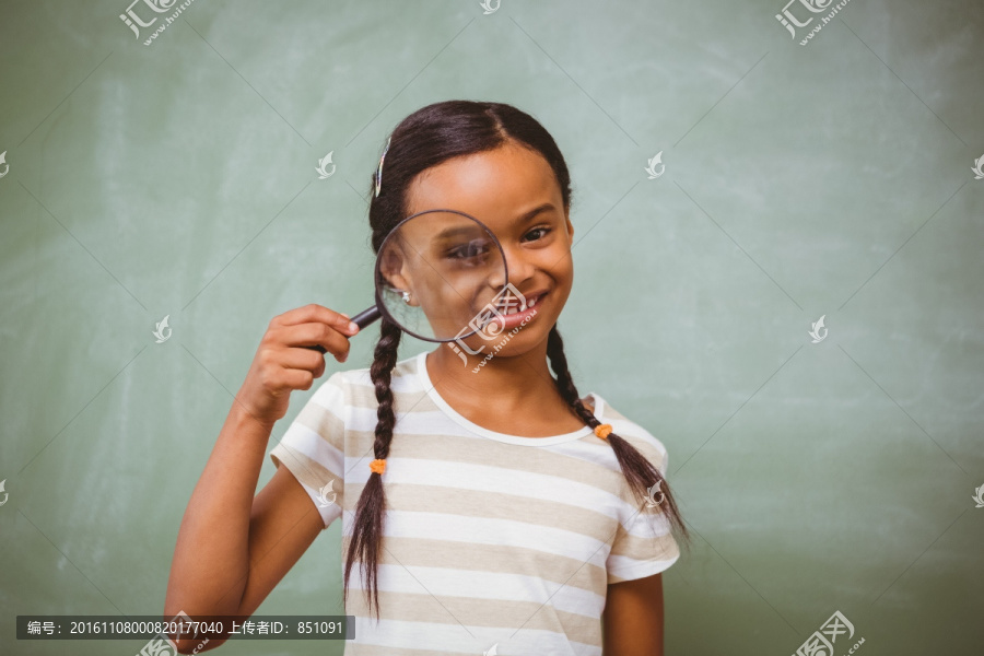 小女孩在教室里拿着放大镜