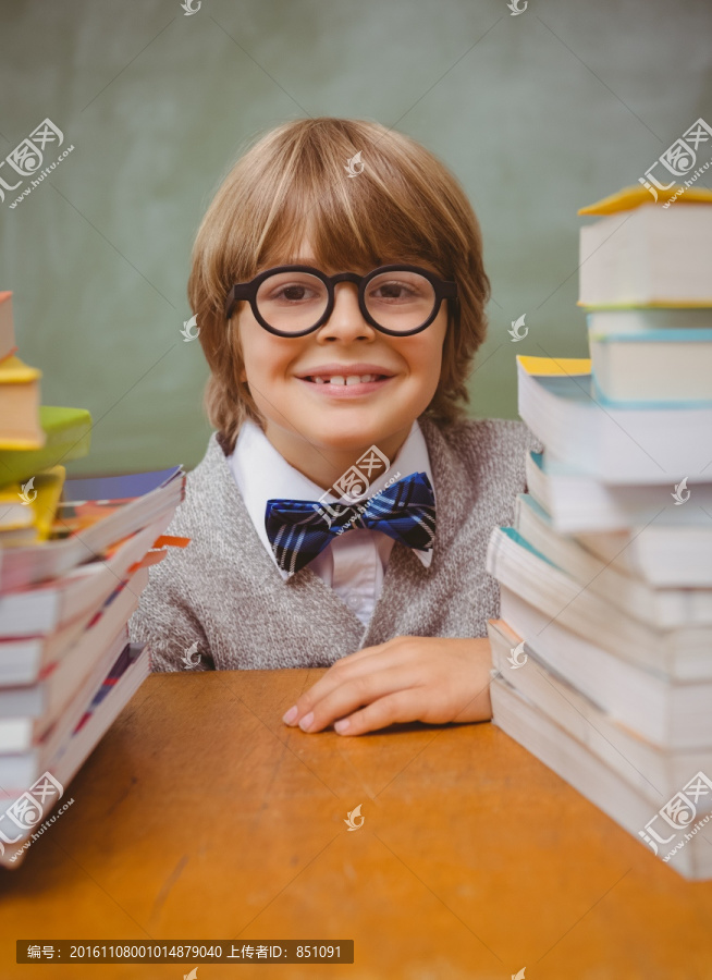 微笑的男孩坐在课桌前
