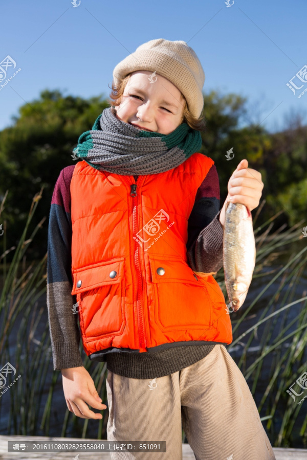 抓着一条鱼的小男孩