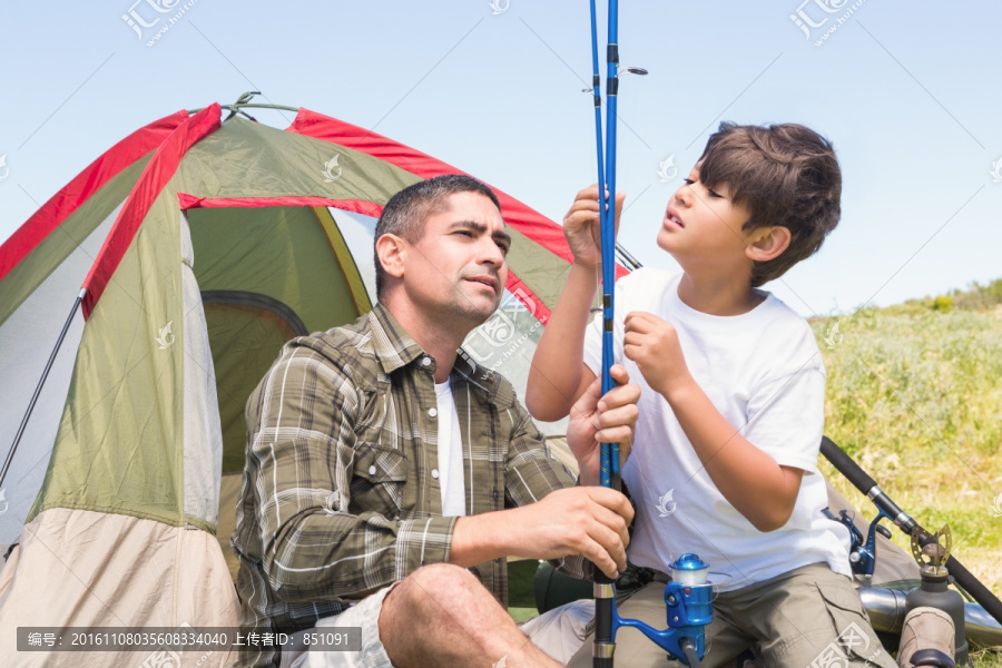 父亲和儿子在帐篷里调整钓鱼竿