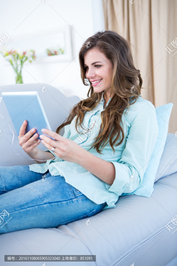 坐在沙发上使用平板电脑的女人