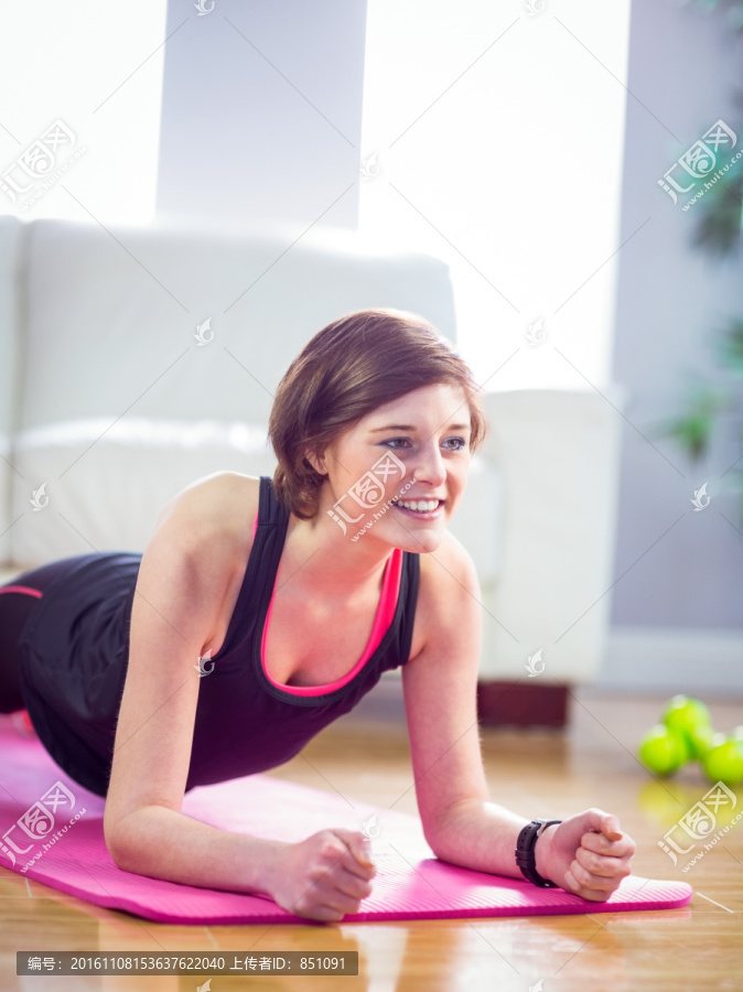 在客厅里做平板支撑运动的女人