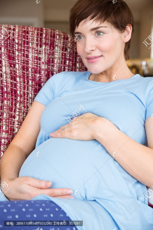 怀孕的女人在沙发上放松