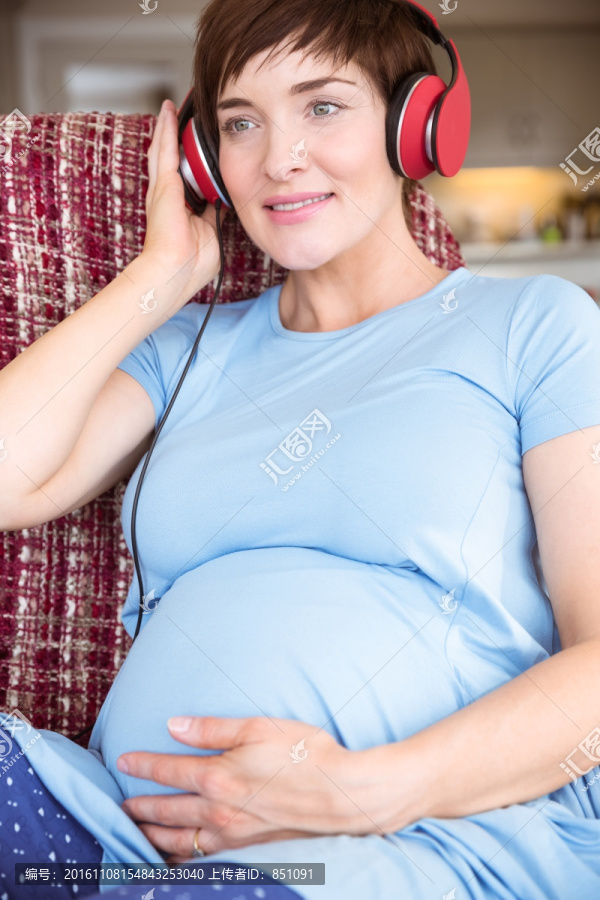 戴着耳机听音乐的孕妇