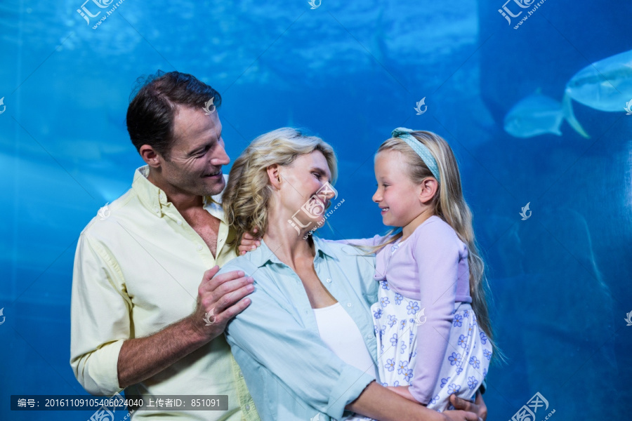 幸福的家庭看着鱼缸里的鱼