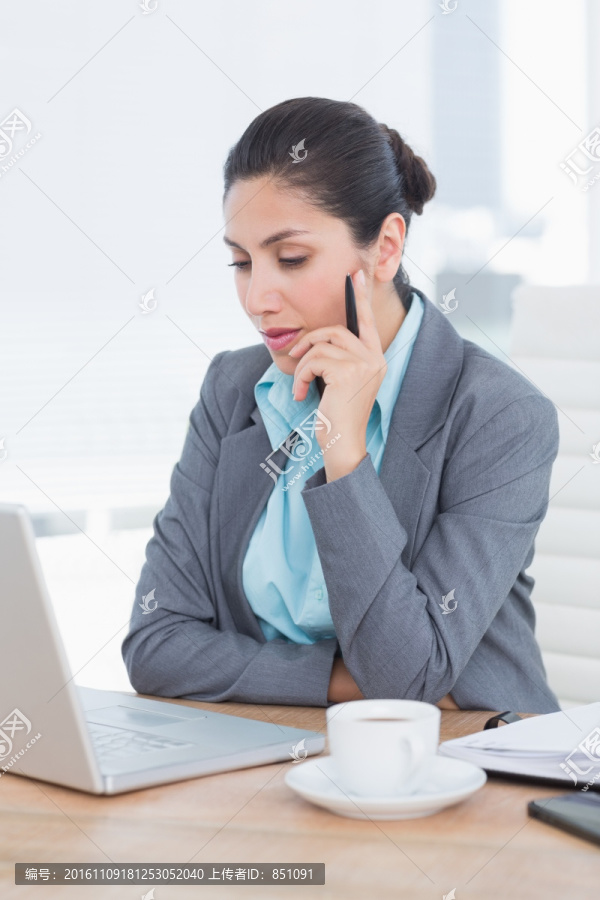 看着笔记本电脑思考的商务女人