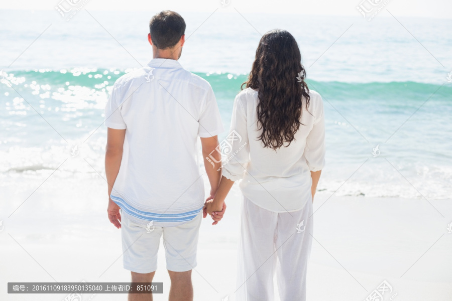 牵着手在海边的夫妇