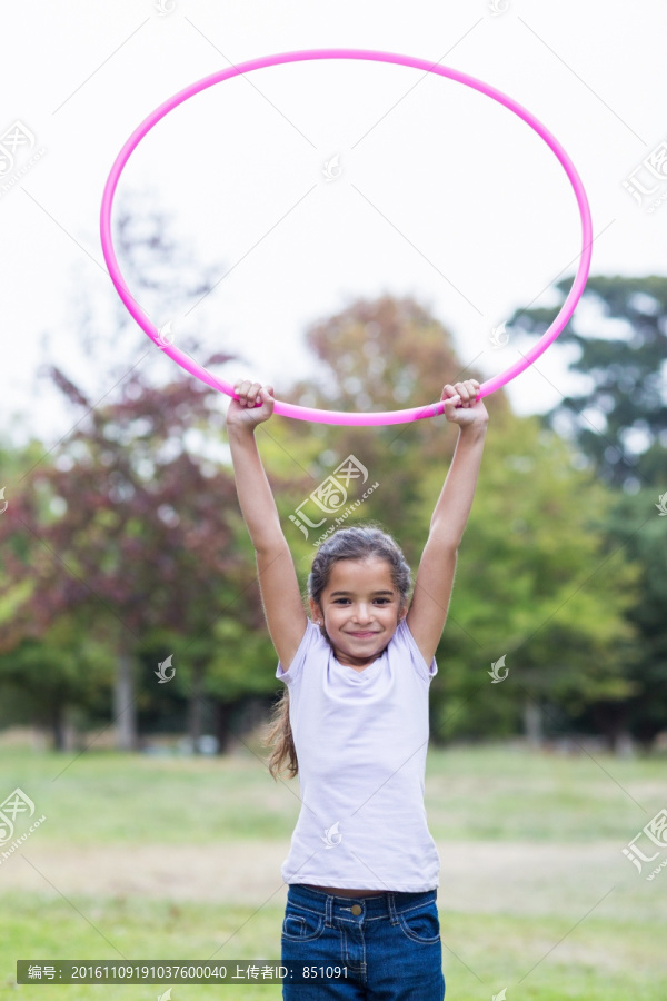 拿着呼啦圈的小女孩在公园里