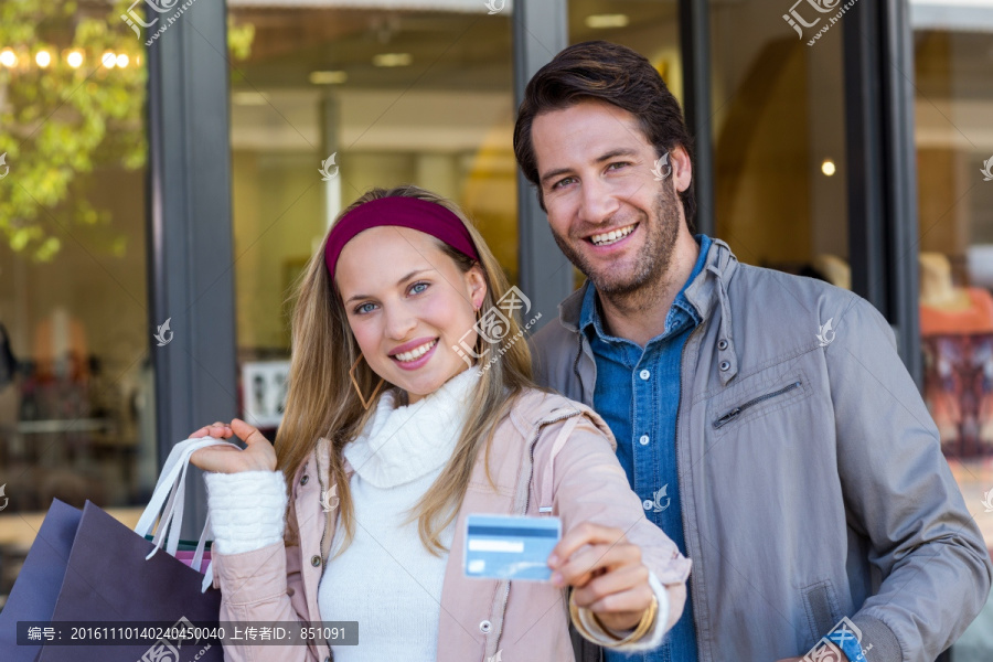 微笑着拿着信用卡的男女