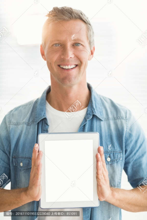 微笑着拿着平板电脑的商务男人