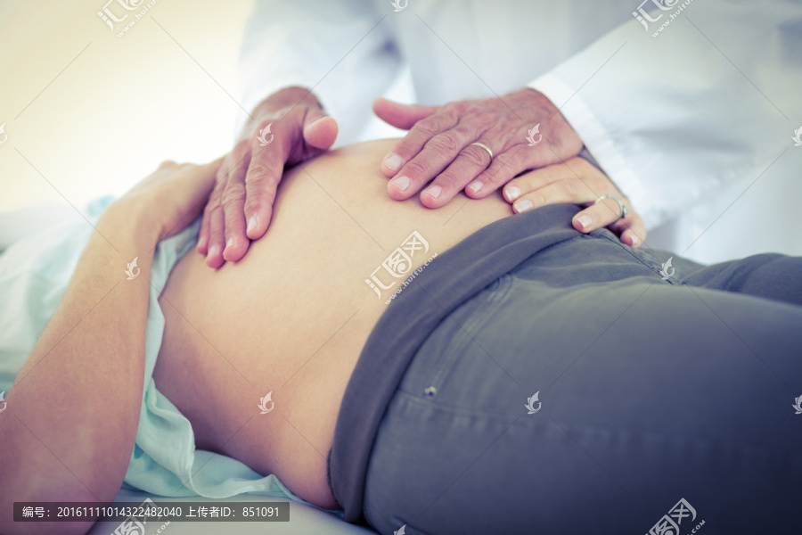 躺在病床上接受医生检查的孕妇