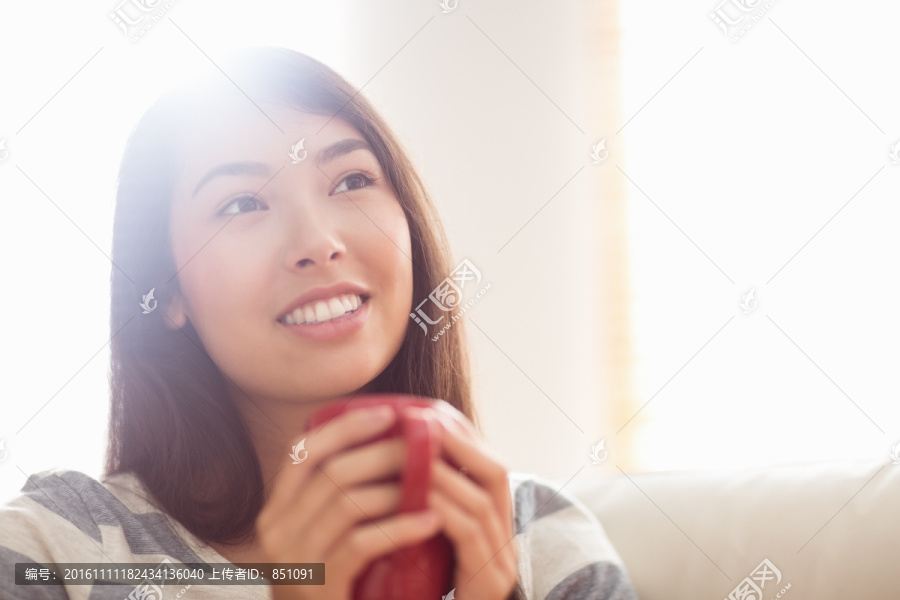 微笑的女人拿着一杯咖啡