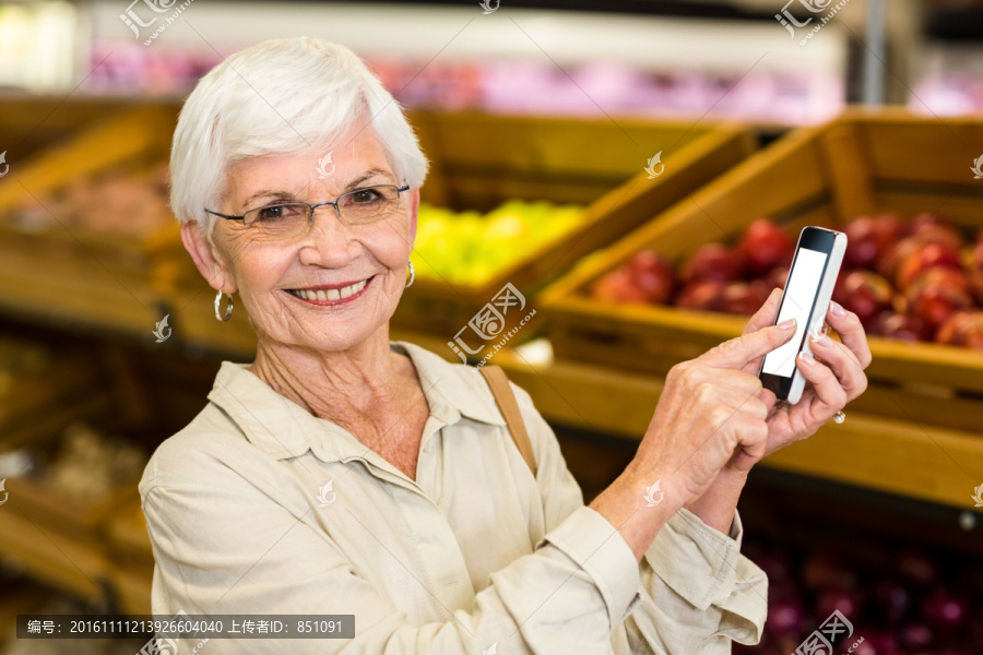 在超市里使用手机的老太太