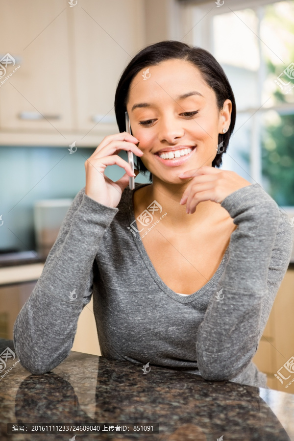 在厨房里用手机打电话的女人