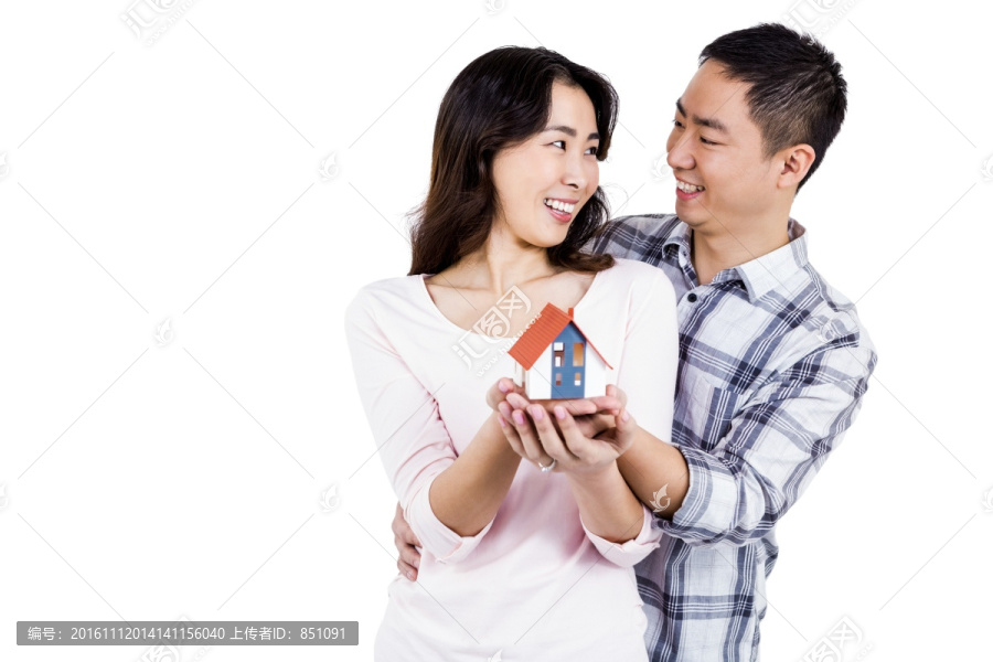 微笑着拿着房屋模型的夫妇