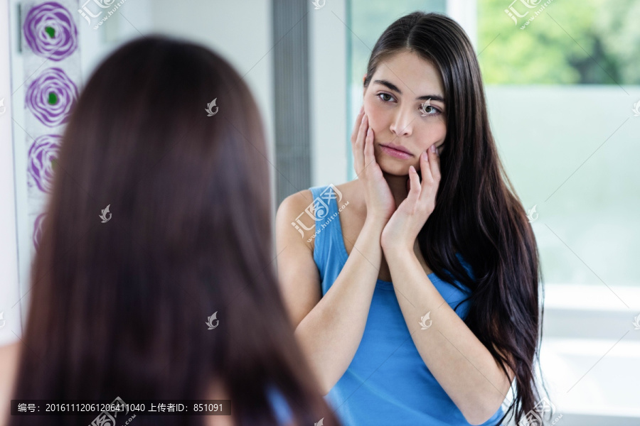 不开心的女人照着镜子