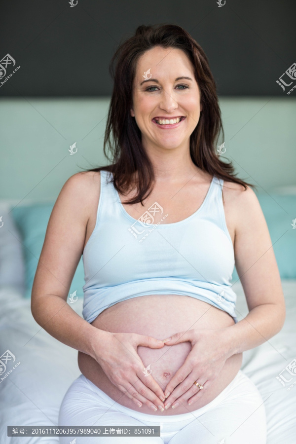 双手放在肚子上的孕妇