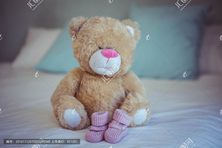床上的泰迪熊和婴儿袜