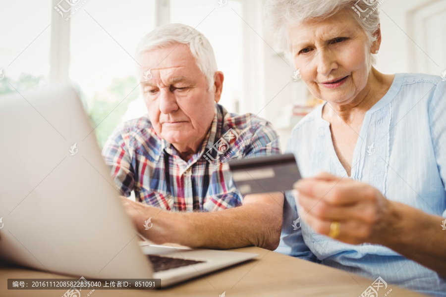 一对老夫妇使用笔记本电脑网购