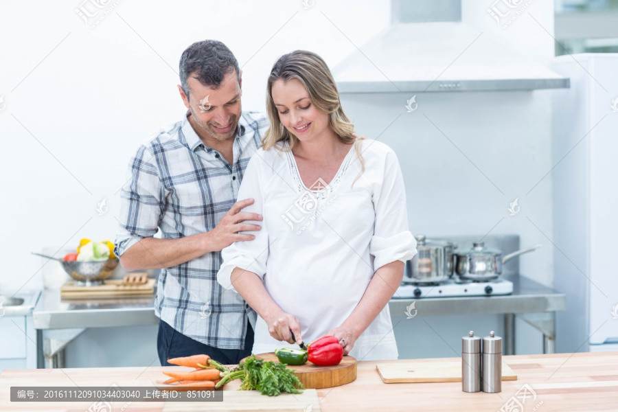 孕妇忙着在厨房切蔬菜