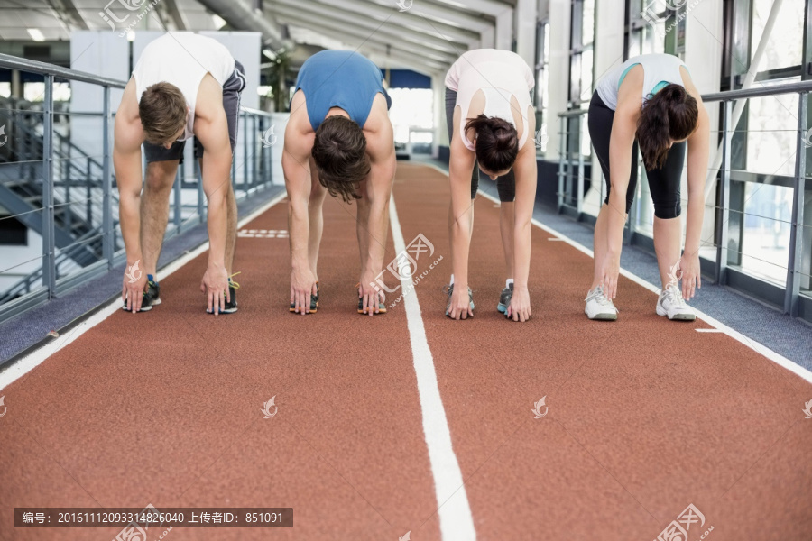 站在跑道上做伸展运动的健身小组