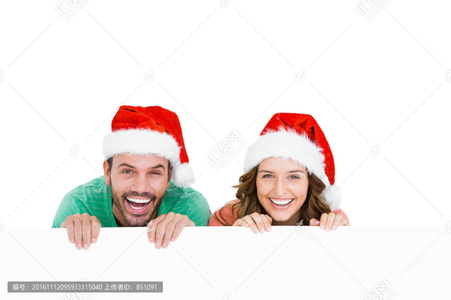 快乐的年轻夫妇戴着圣诞帽