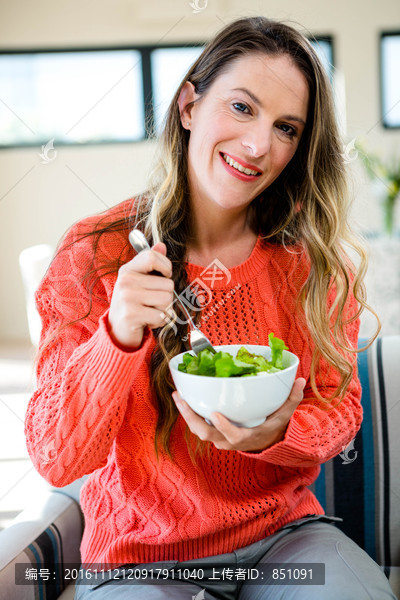 微笑的女人吃一碗沙拉