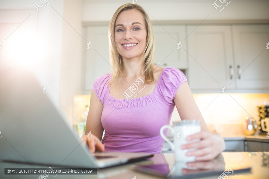 边喝咖啡边用笔记本电脑的女人