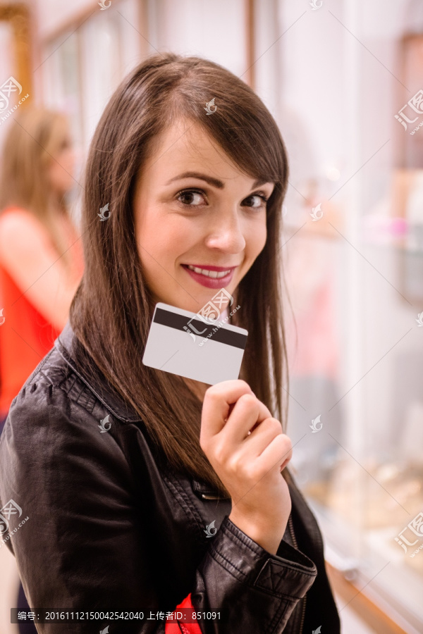 在商场里拿着一张银行卡的女人