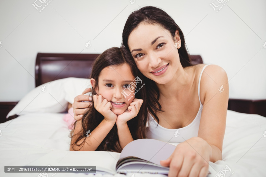 趴在床上看书的母亲和女儿