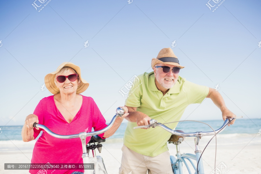 在海边骑自行车的老夫妇