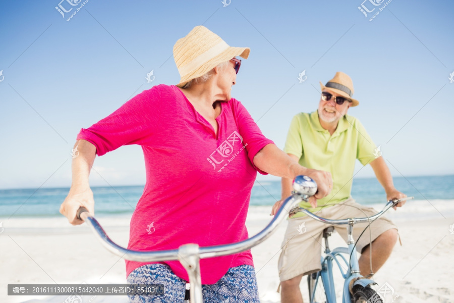 在沙滩上骑自行车的老夫妇