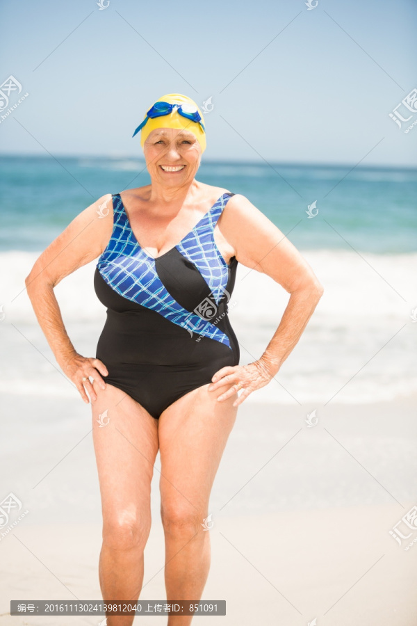 微笑的老太太站在沙滩上