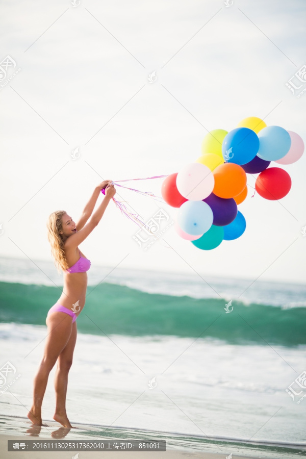 拿着气球在海边的女人