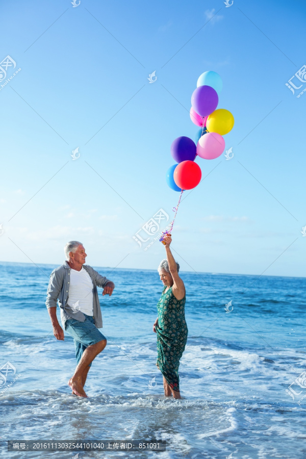 在海边拿着气球的老太太
