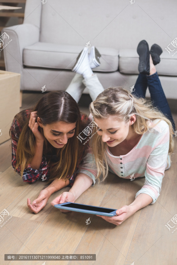 趴在地板上使用平板电脑的朋友