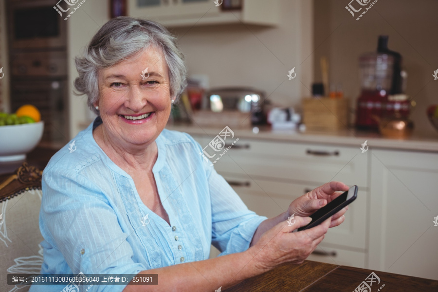 微笑的老太太在使用手机